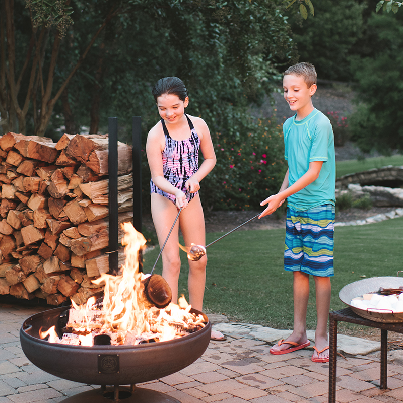 Kids cooking smores over a firepit